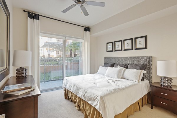 Modern bedroom with large windows overlooking lake at One Lakes Edge luxury apartments