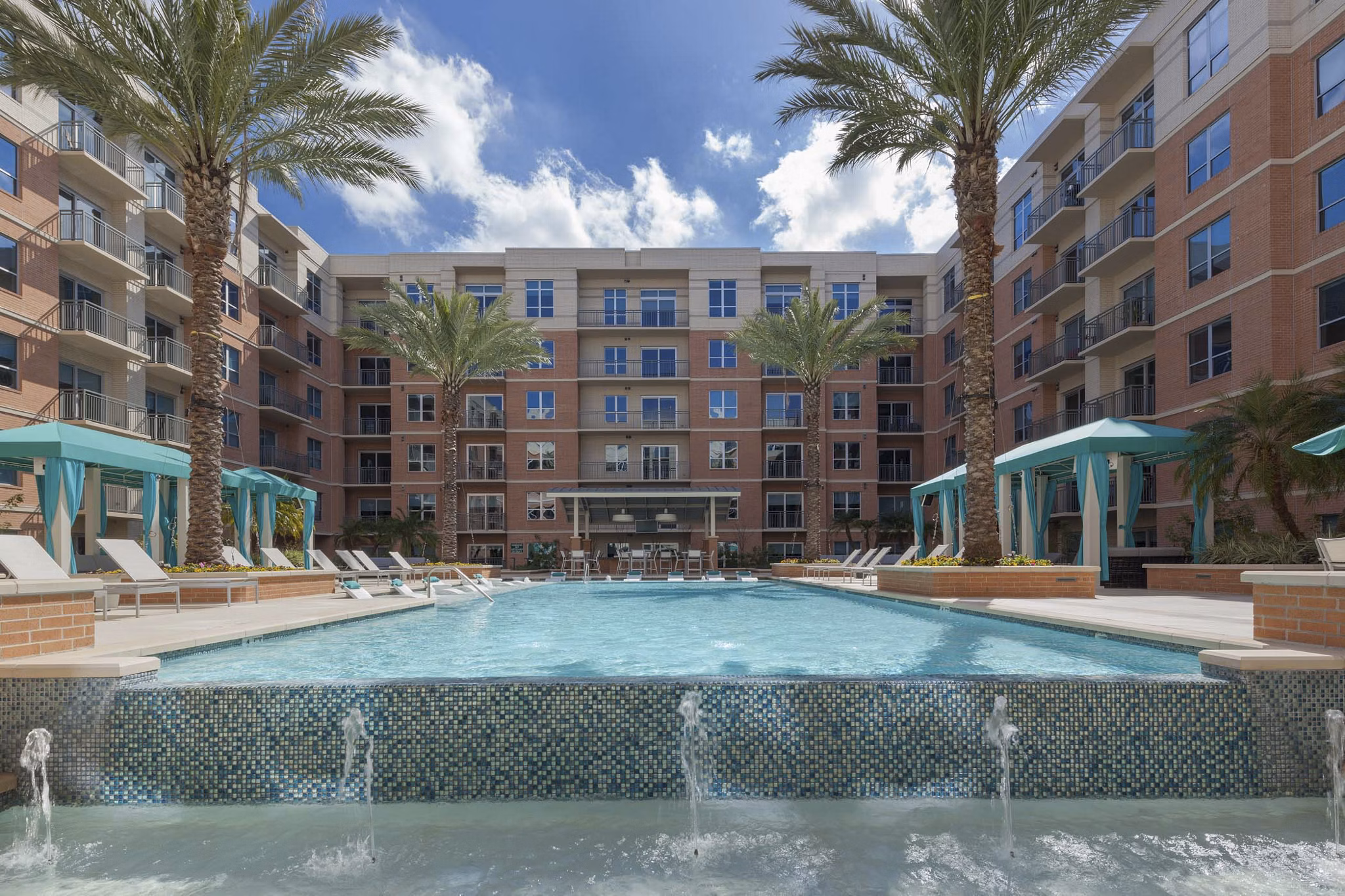 Relaxing outdoor pool area with lush greenery at One Lakes Edge luxury apartments, perfect for unwinding and leisure activities