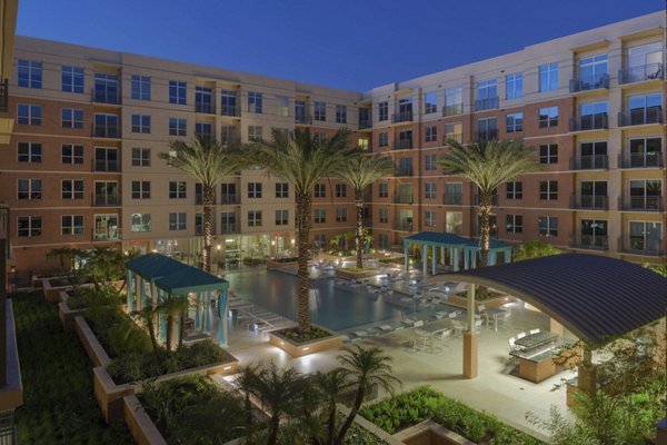 Luxurious pool area with loungers at One Lakes Edge, offering relaxation and stunning waterfront views for residents