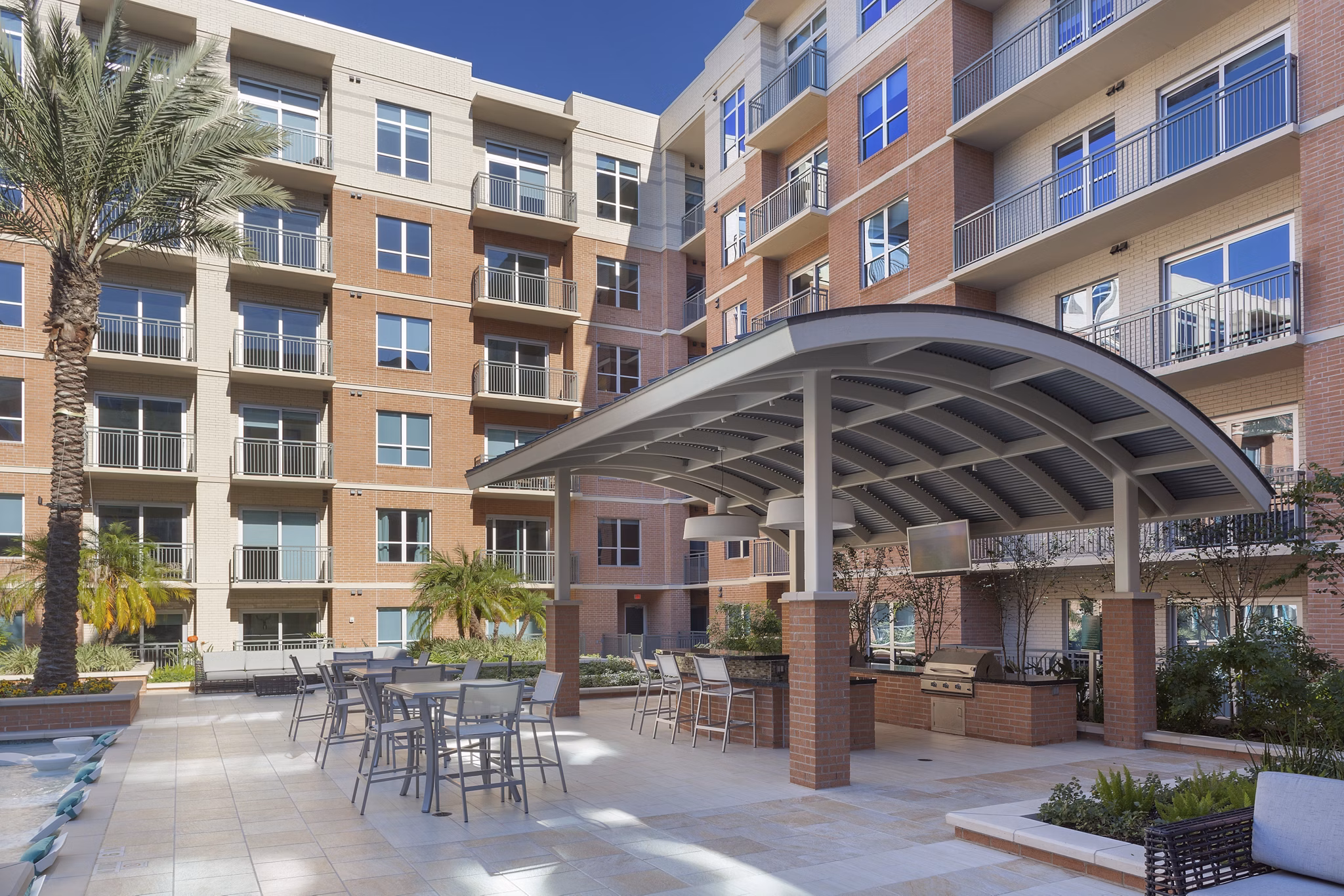 Serene courtyard featuring manicured gardens and seating areas at One Lakes Edge apartments