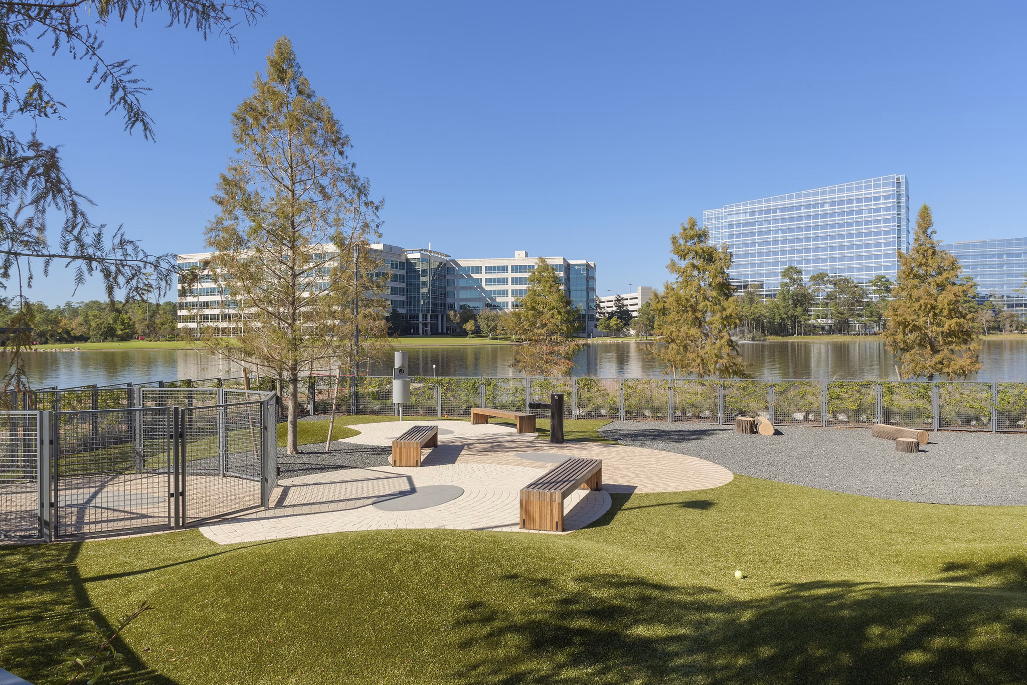 Pet-friendly dog park at One Lakes Edge featuring agility equipment and lush green spaces