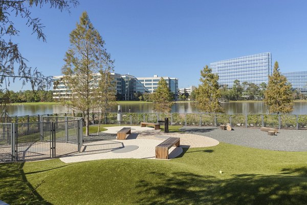 Pet-friendly dog park at One Lakes Edge featuring agility equipment and lush green spaces