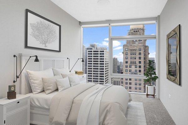 Contemporary bedroom with chic decor and large windows at Aston Apartments