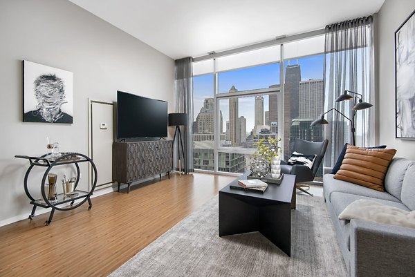 Living room with modern furniture and large windows at Aston Apartments