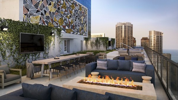 Rooftop deck with lounge seating and skyline views at Aston Apartments