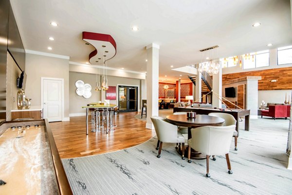 Clubhouse with modern decor at Jones Grant Luxury Apartments in Raleigh, featuring luxury seating, games, and entertaining spaces