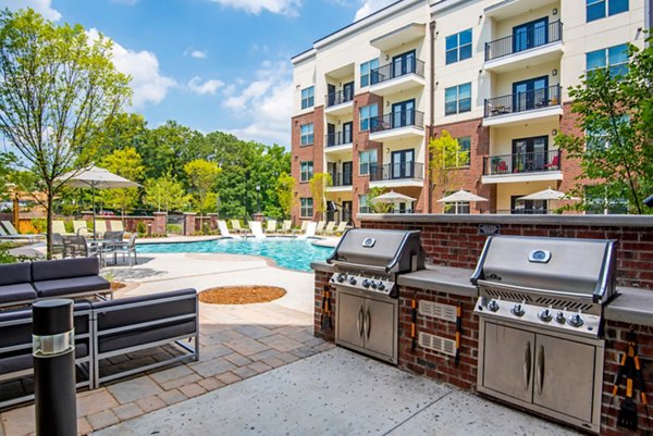 Outdoor grill area with modern seating at Jones Grant Luxury Apartments