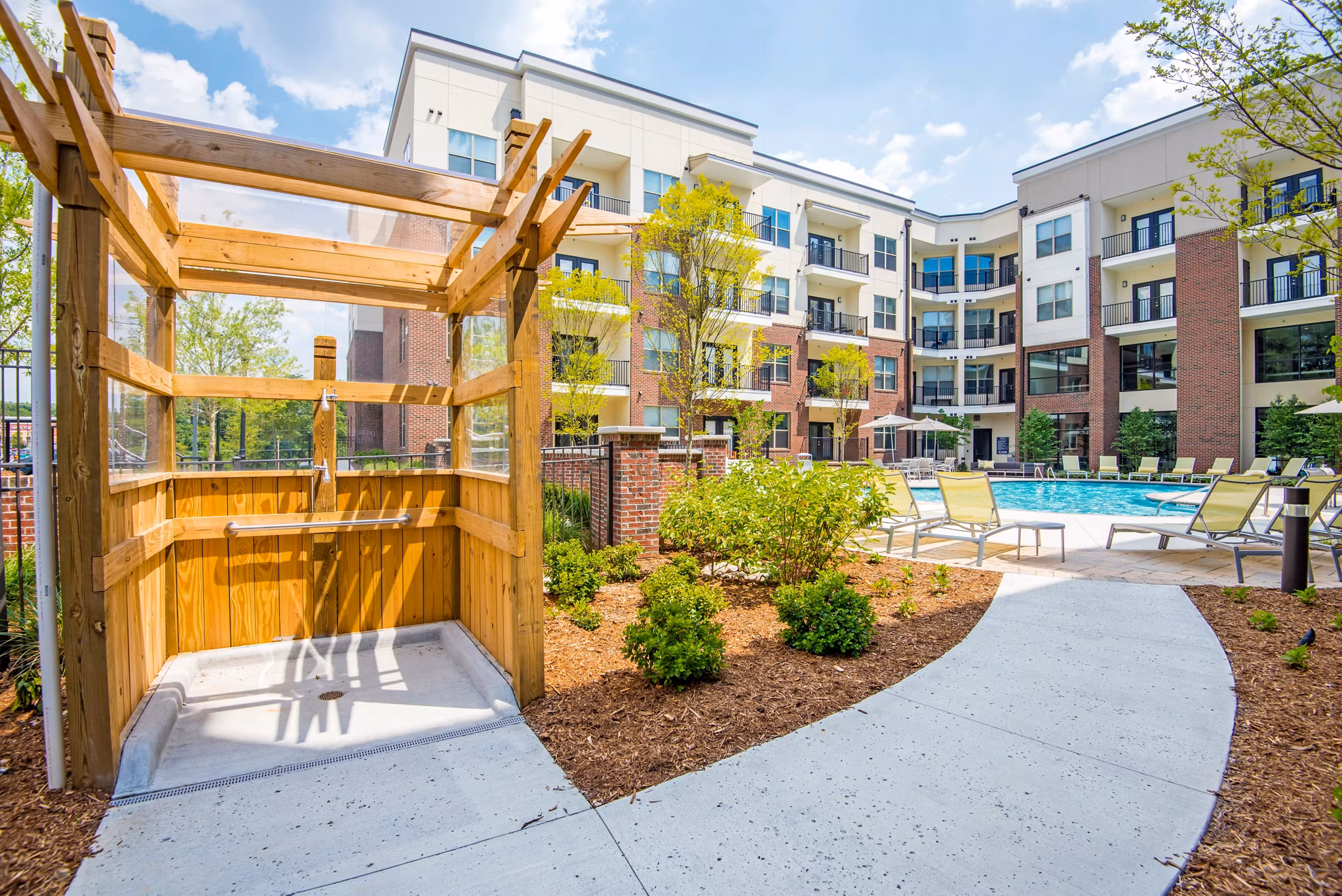 Jones Grant Luxury Apartments: Outdoor swimming pool with sun loungers and landscaping