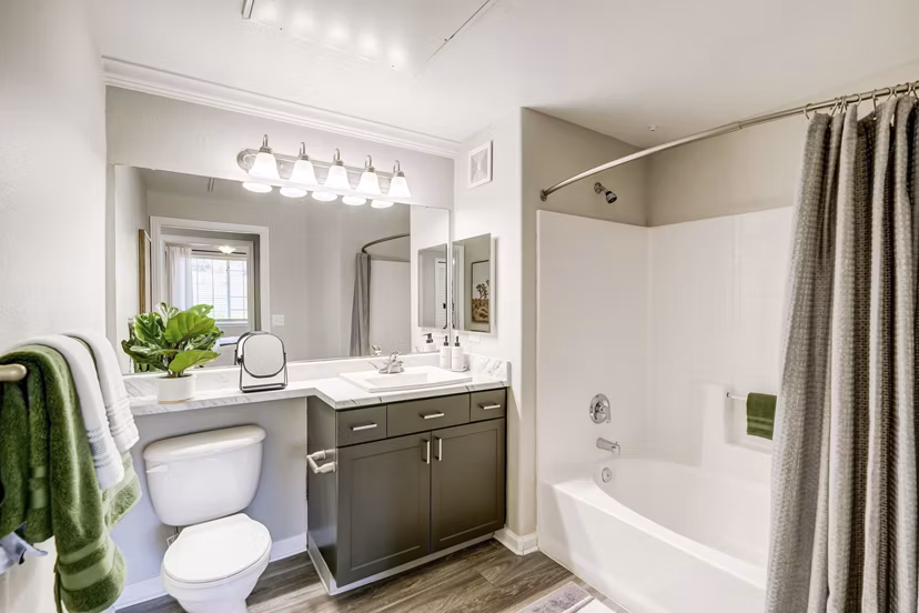 Modern bathroom with sleek fixtures and large mirrors in Champions Apartments, offering luxury living