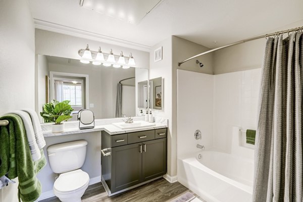 Modern bathroom with sleek fixtures and large mirrors in Champions Apartments, offering luxury living