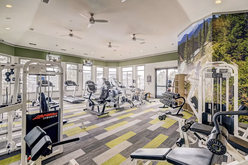 State-of-the-art fitness center with various equipment at Champions Apartments