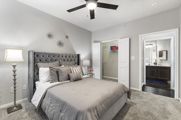 Cozy bedroom featuring modern decor and large windows in Villages at Turtle Rock Apartments