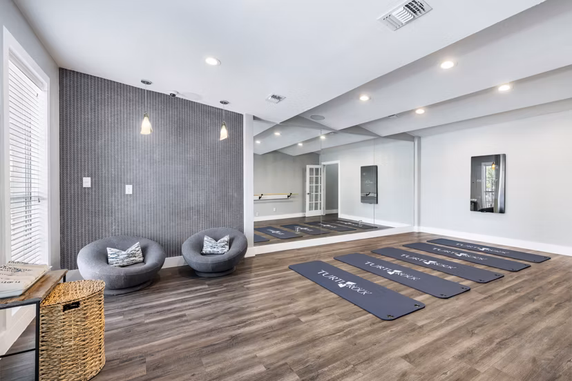 Yoga and spin studio with mirrored walls and exercise bikes at Villages at Turtle Rock Apartments