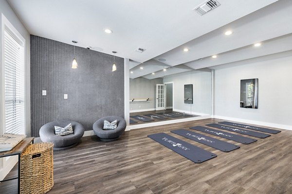 Yoga and spin studio with mirrored walls and exercise bikes at Villages at Turtle Rock Apartments