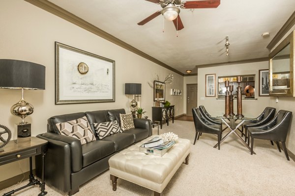 Bright living room with contemporary decor at Deerwood Apartments, featuring plush seating and large windows for natural light