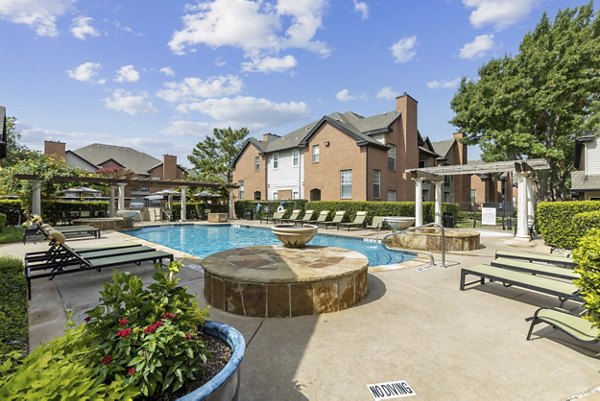Poolside relaxation at Towns of Chapel Hill Apartments featuring luxurious pool with lounge chairs and landscaped surroundings, perfect for unwinding