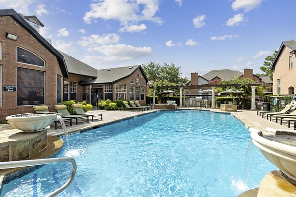 Infinity-edge pool surrounded by lush landscaping at Towns of Chapel Hill Apartments