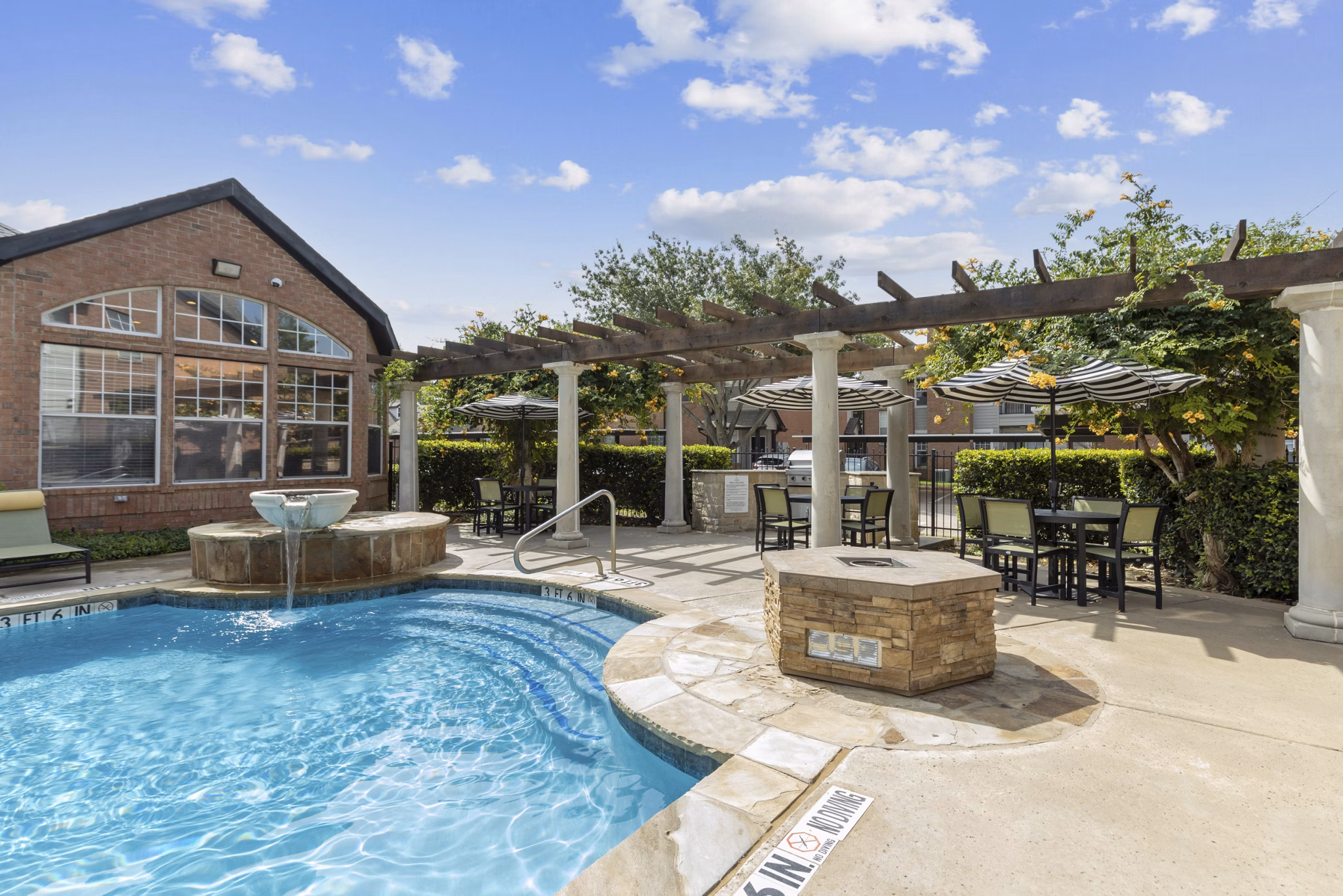 Luxurious pool at Towns of Chapel Hill Apartments with lounge chairs and greenery for relaxation