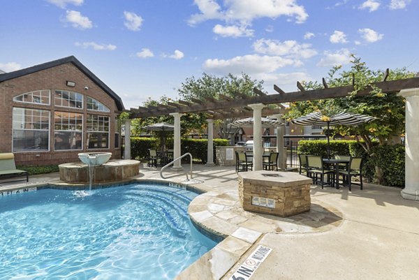 Luxurious pool at Towns of Chapel Hill Apartments with lounge chairs and greenery for relaxation