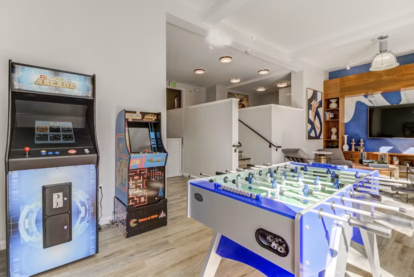 Game room with arcade machines and foosball table at luxury apartments