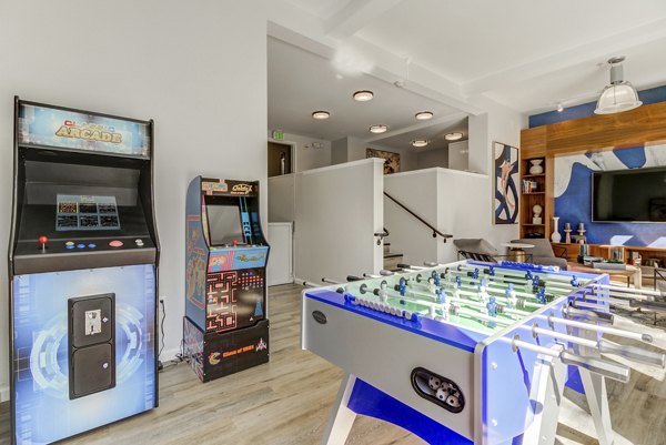 Game room with arcade machines and foosball table at luxury apartments