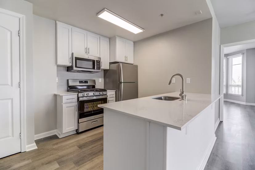 Hillside Village Apartments: Modern kitchen with stainless steel appliances and granite countertops in luxury apartment community