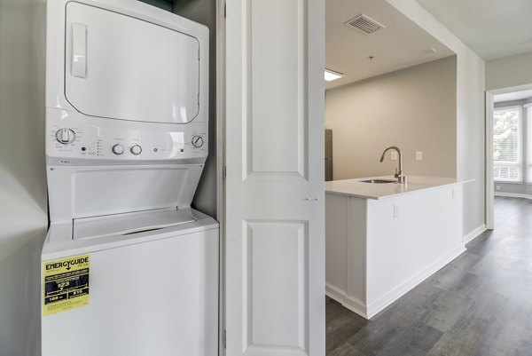 Modern laundry room with high-efficiency washers and dryers at Hillside Village Apartments