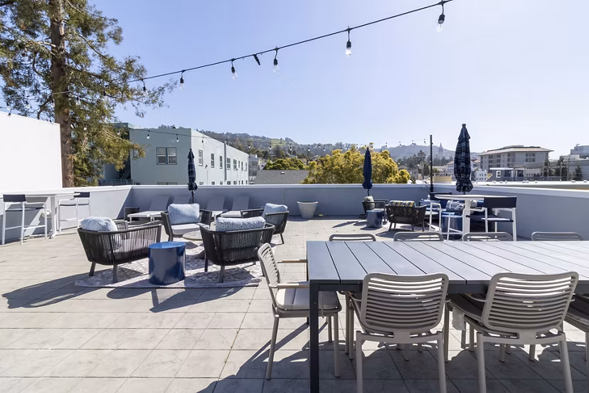 Rooftop deck with seating and greenery at Hillside Village Apartments