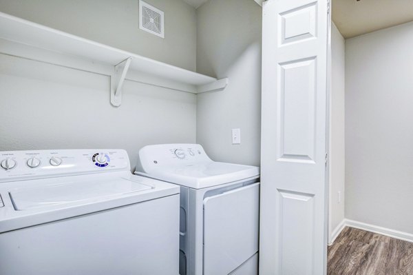 Modern laundry room with high-efficiency washers and dryers at Waterford Cherry Creek Apartments