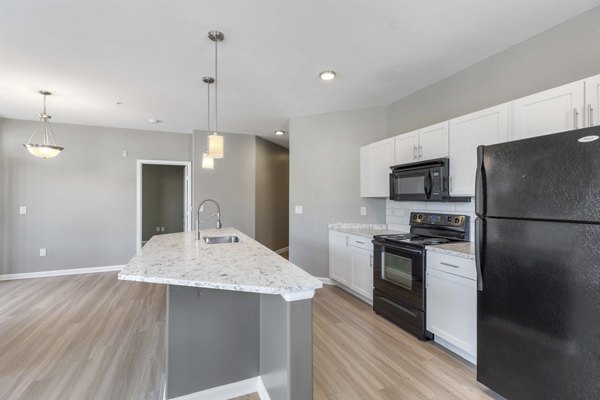 Modern kitchen with stainless steel appliances and granite countertops at Vue 21 Apartments