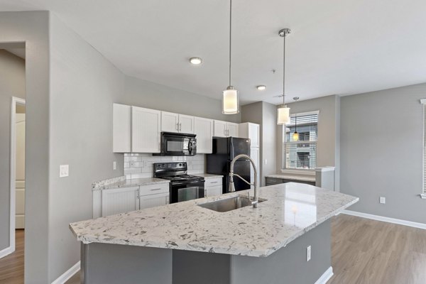 Modern kitchen with stainless steel appliances and granite countertops at Vue 21 Apartments