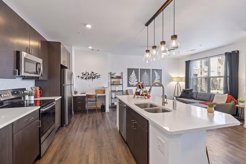 Modern kitchen with stainless steel appliances and granite countertops at Vue 21 Apartments