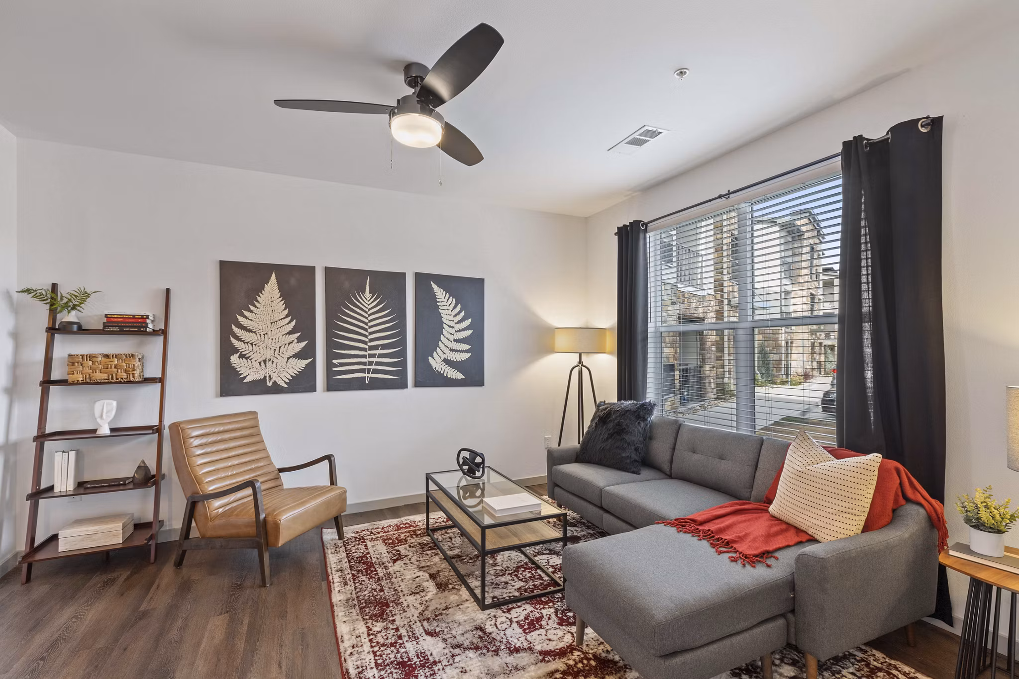 Spacious living room with plush seating and large windows in Vue 21 Apartments