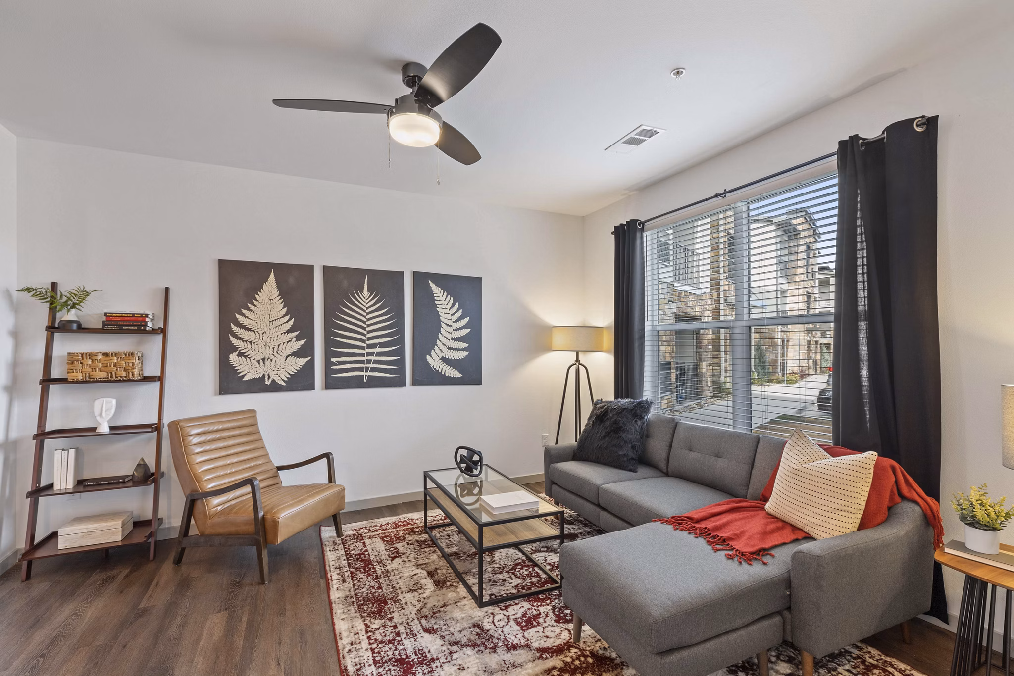 Spacious living room with plush seating and large windows in Vue 21 Apartments