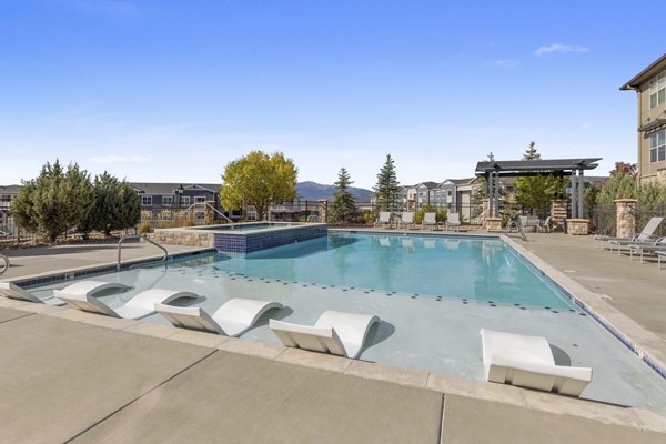 Resort-style pool at Vue 21 Apartments featuring sun loungers and palm trees