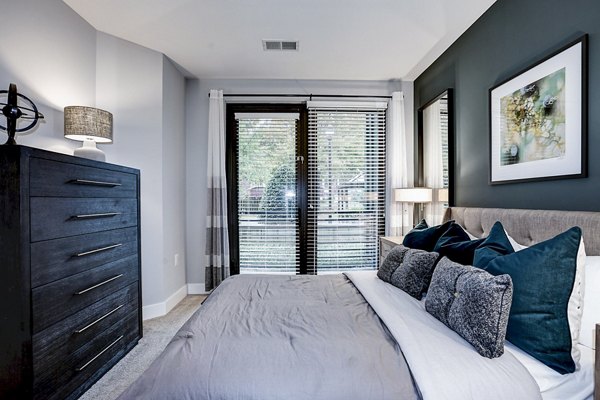 Cozy bedroom with modern decor at Del Ray Central Apartments, ideal for comfortable living in luxurious Greystar-managed property