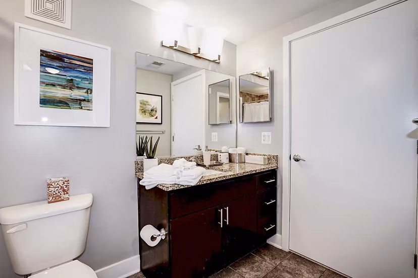 Modern bathroom with sleek fixtures and large mirror at Del Ray Central Apartments in Alexandria