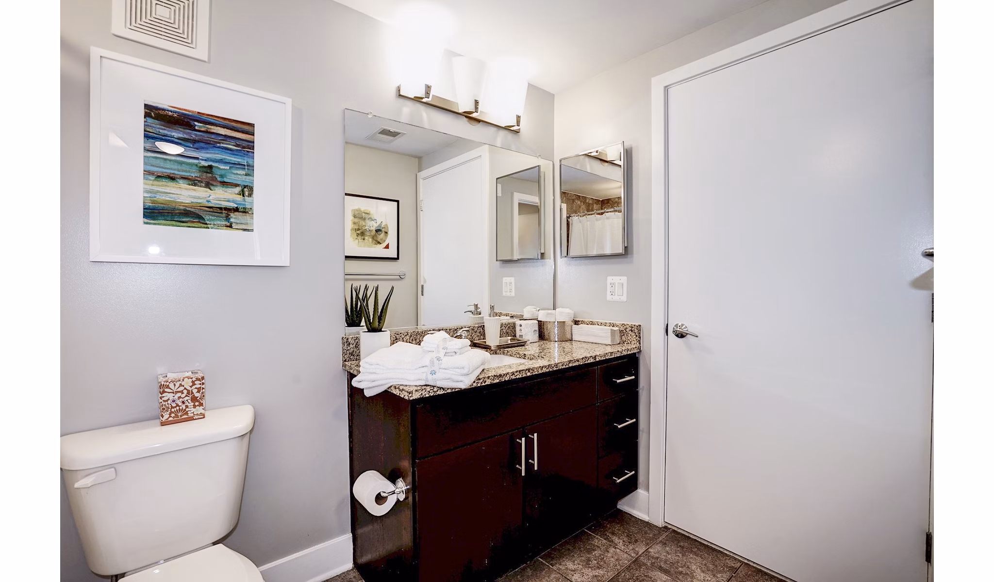 Modern bathroom with sleek fixtures and large mirror at Del Ray Central Apartments in Alexandria