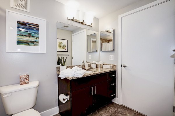 Modern bathroom with sleek fixtures and large mirror at Del Ray Central Apartments in Alexandria