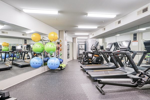 Modern gym featuring treadmills, exercise balls, and mirrors in luxury apartment community