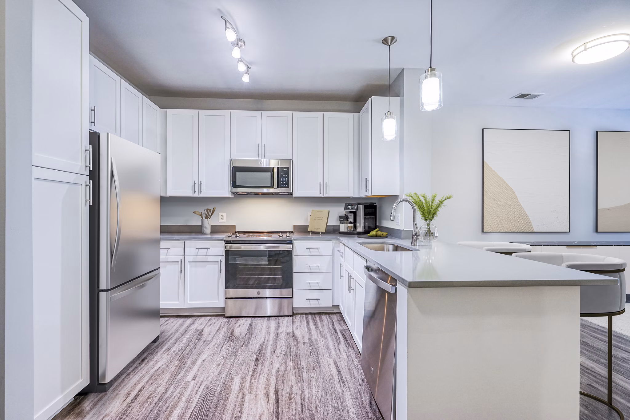 Modern kitchen featuring stainless steel appliances and marble countertops in Del Ray Central Apartments