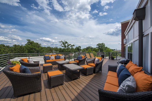 Outdoor patio with wicker furniture and orange cushions in luxury apartment community