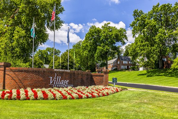 Village at Fox Point: Beautifully landscaped entrance with flowers and flags in a charming residential community