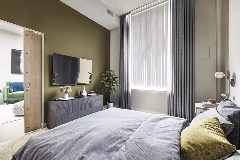 Elegant bedroom with plush bedding and large windows at Massachusetts Court Apartments