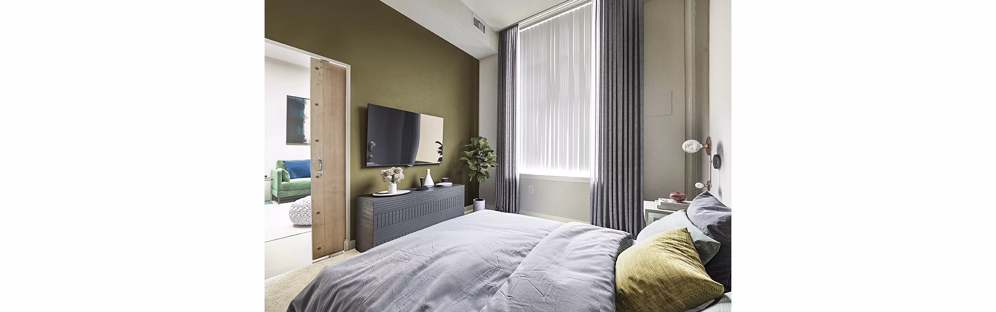 Elegant bedroom with plush bedding and large windows at Massachusetts Court Apartments
