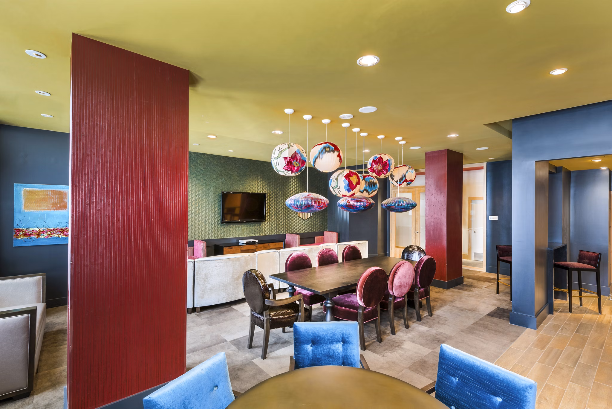 Modern dining area with a long table, decorative lighting, and TV in luxury apartments