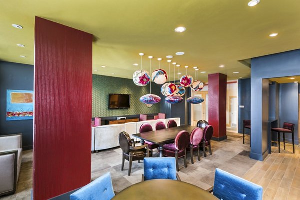 Modern dining area with a long table, decorative lighting, and TV in luxury apartments
