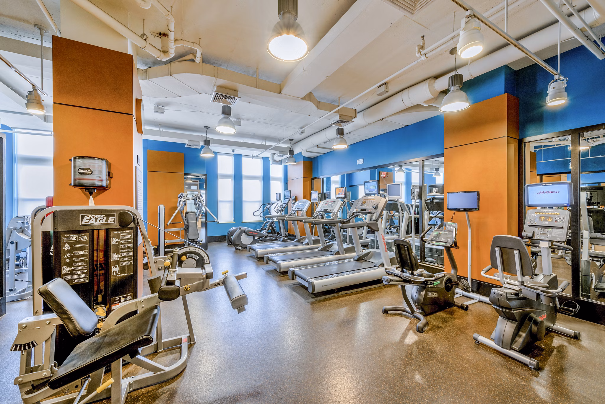 Modern gym featuring treadmills, stationary bikes, and weight machines in luxury apartments