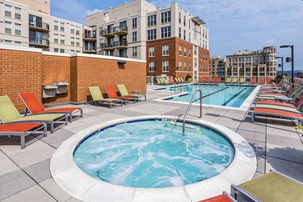 Rooftop pool and hot tub with lounge chairs in the luxury apartments courtyard