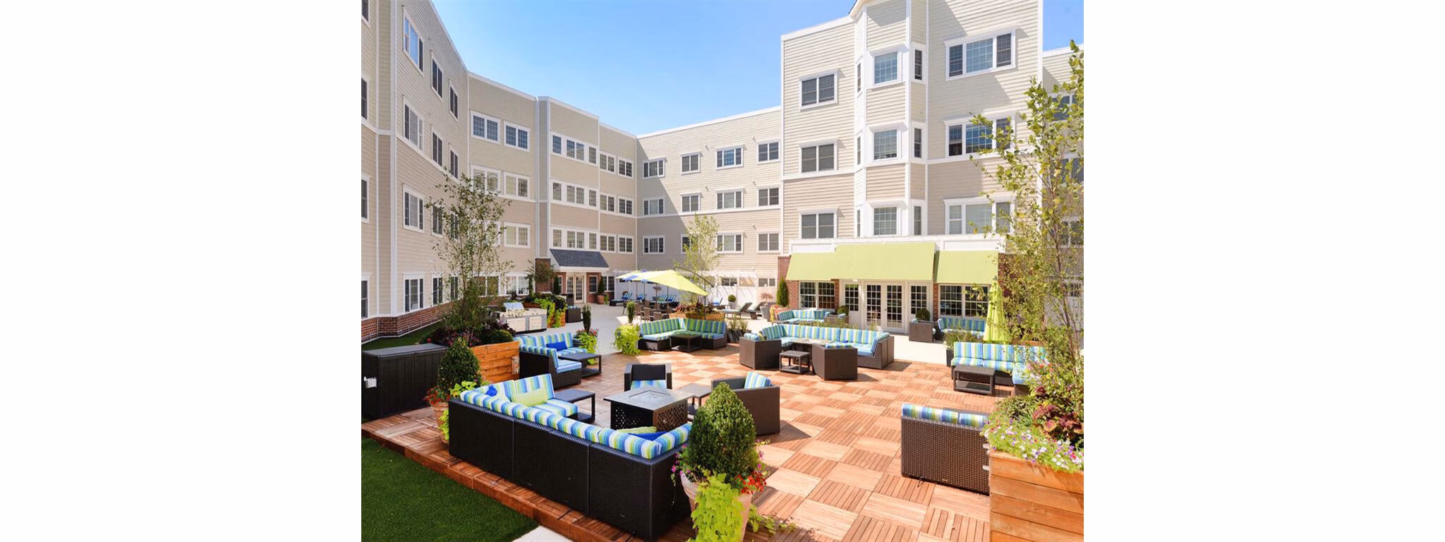 The Hawthorne Apartments: Serene courtyard with lush greenery and seating area